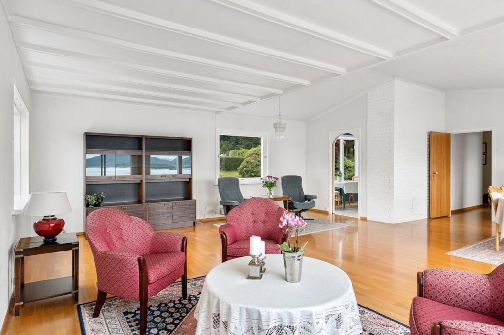 A living room with red chairs and a white rug