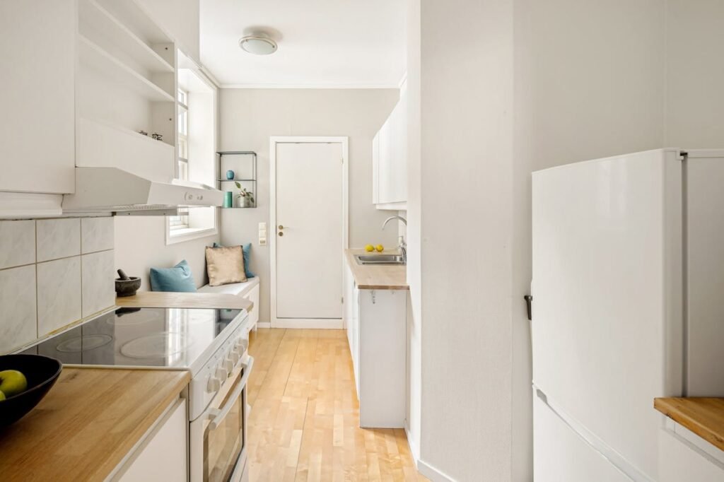 A white kitchen with a refrigerator and stove